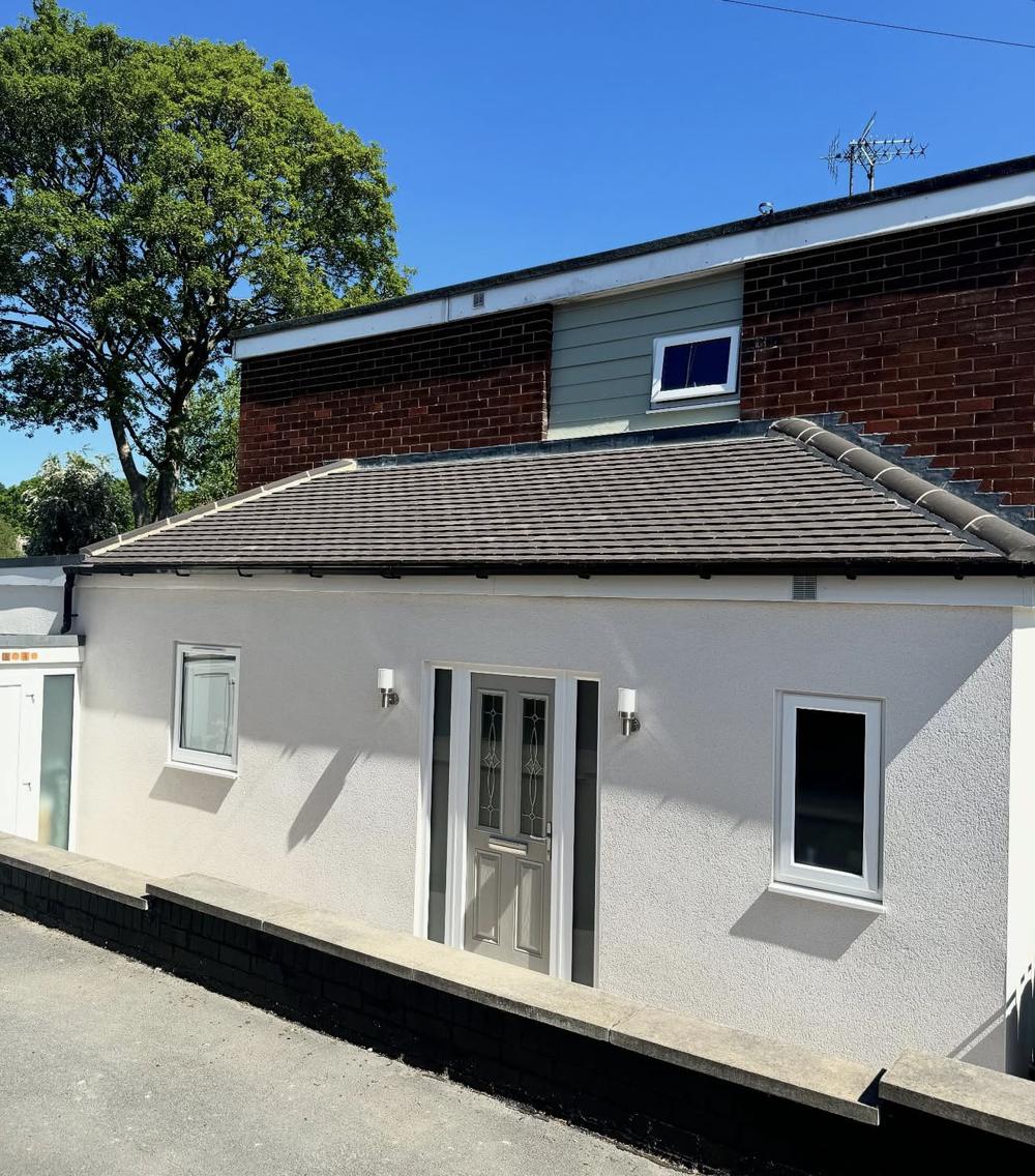 Front of the extension with a new door, windows and render